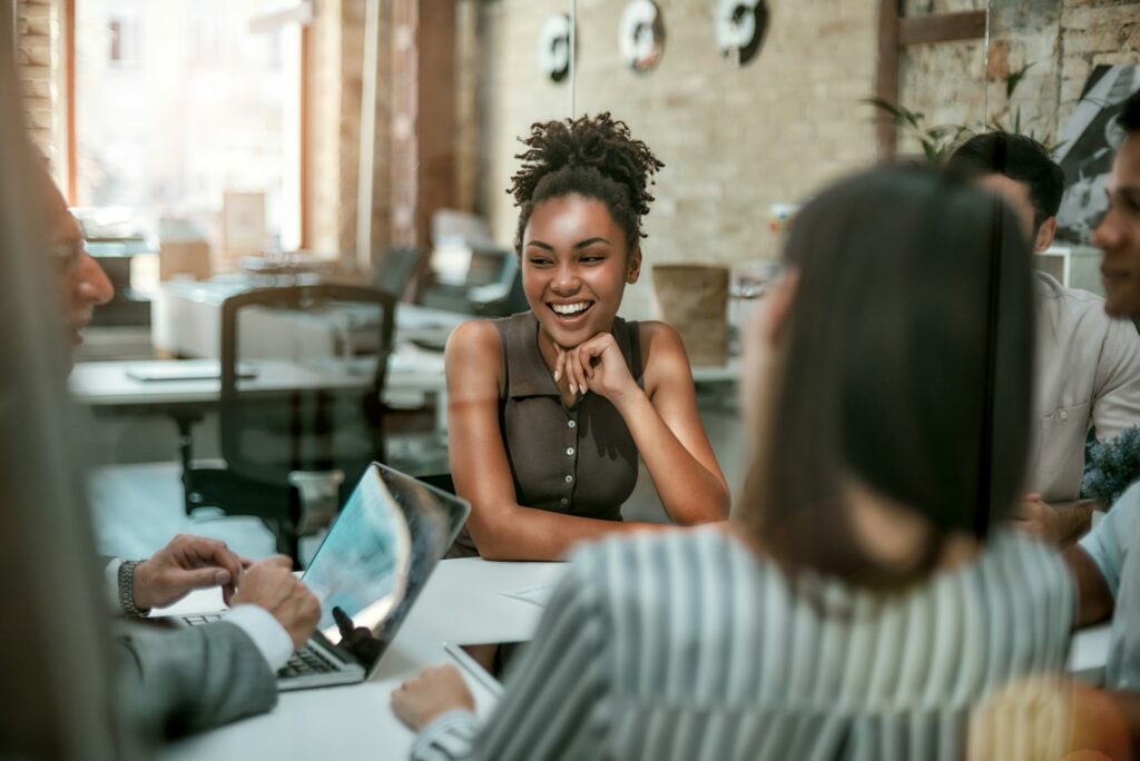 We are one team. Young and cheerful afro american woman smiling while having a meeting with